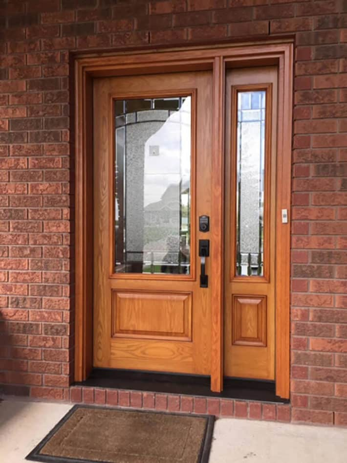 A detail shot of a professional door installation by Quality Contracting in Verner, featuring spray foam insulation, new trim, and hardware.