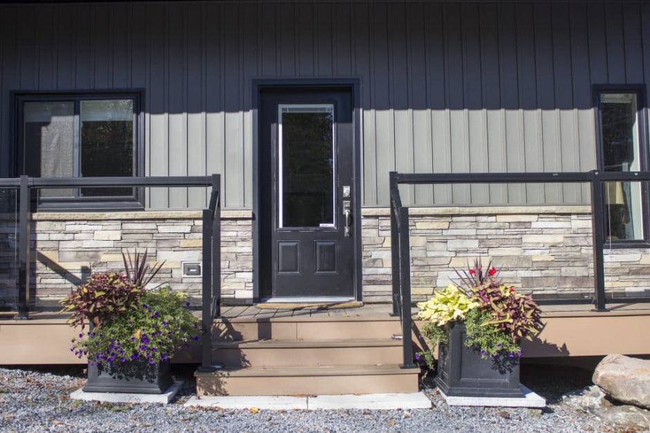 Reg Piquette of Quality Contracting discussing window and siding options with a homeowner during a free estimate in Crystal Falls, Ontario.