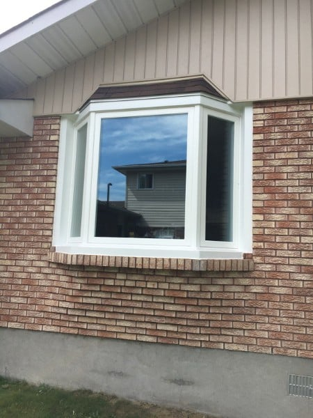 A renovated home in St. Charles, Ontario, featuring new energy-efficient windows, a steel entry door, and durable vinyl siding installed by Quality Contracting.